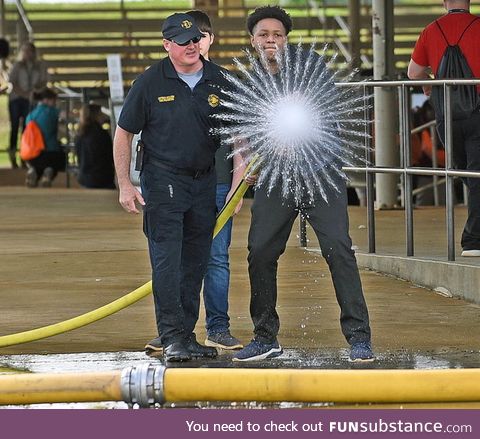 This student starting a firehose and a photo being taken at the exact moment. That water