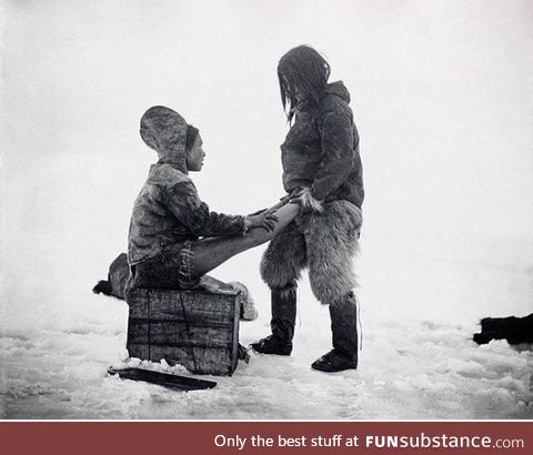 The Inuit man from Greenland warms the wife’s feet, circa 1891