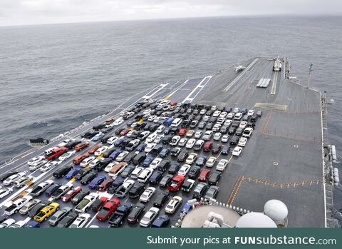 Just a bunch of cars parked on the deck of an aircraft carrier