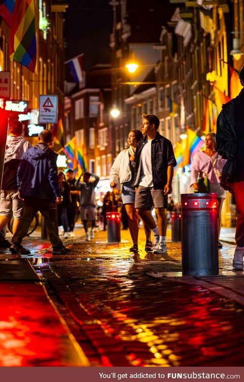 A couple exploring Amsterdam's Red Light District during Pride