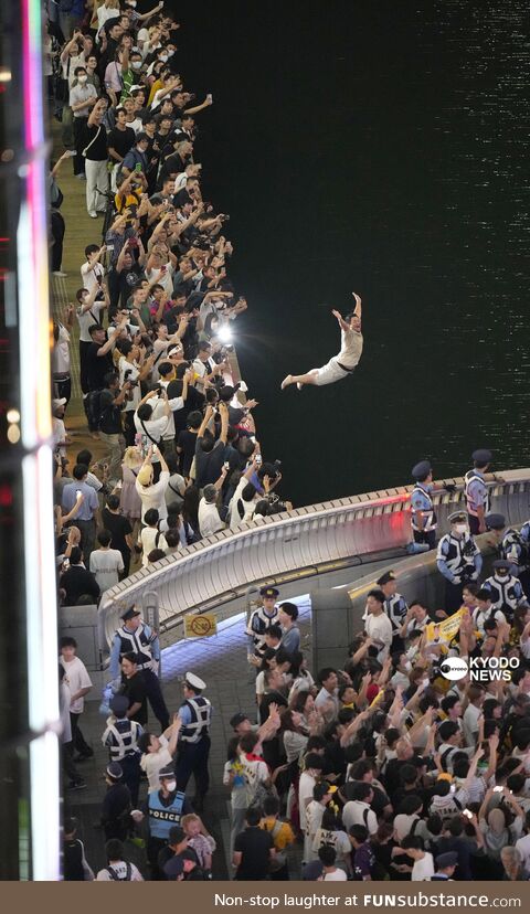A man dive into Dotonbori after Hanshin Tigers had won the first league title in 18 years