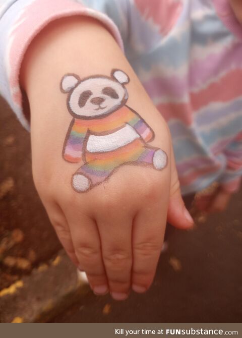 A rainbow panda painted on my kids' hand at a recent neighborhood fair
