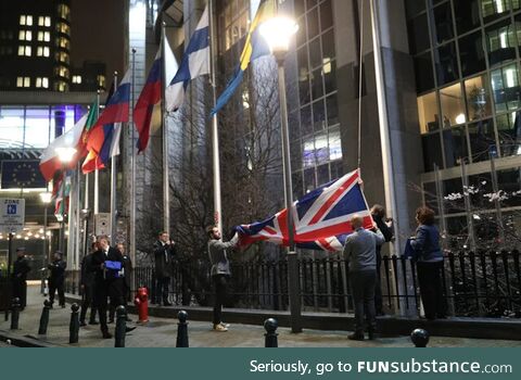 The UK flag being removed from the flagpoles showing the European Parliament; From