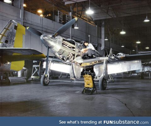 An inspector with North American Aviation checks a Mustang Mk I fighter destined for the