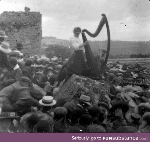 A woman playing a Harp (the symbol of Ireland) at a Gaelic Revival event circa 1910