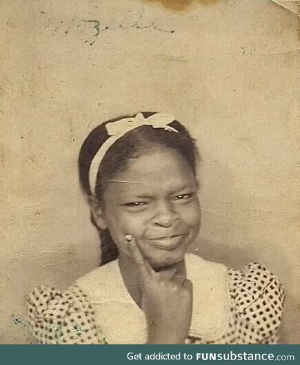 A young girl poses in a photo booth during the 1930s