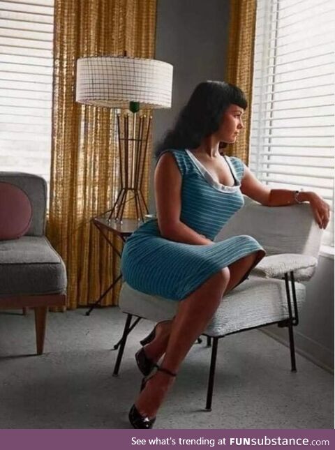 Bettie Page, colorized and gorgeous, posing with some lovely Mid-Century Modern