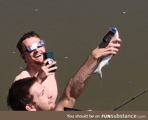 Man shows eclipse to his fish