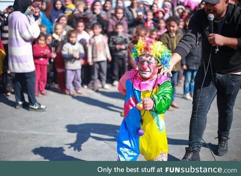 A clown in Gaza cannot hold his tears as he turns his back to the traumatized kids in a