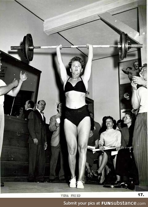 Weightlifting entusiast Vera Fried lifts over 180 pounds overhead to aplause of male gym