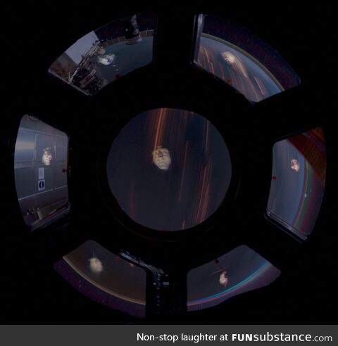 One selfie 7 times, reflected off the windows of the International Space Station