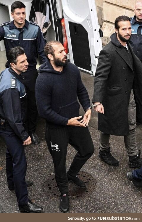 Andrew Tate and his brother Tristan leaving the police van handcuffed together