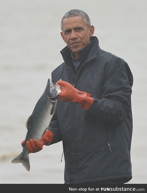 President Barack Obama poses with a fish