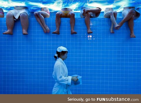 Waitress wearing a bathrobe walks by mannequins at a Beijing restaurant set to look like