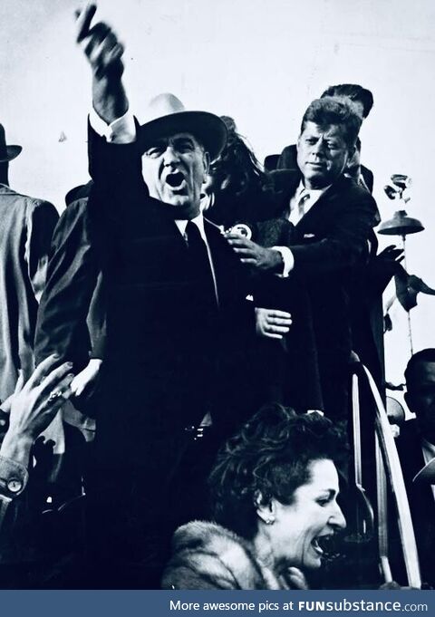 Lyndon b. Johnson yelling to quiet down as john f. Kennedy holds him back. Campaigning